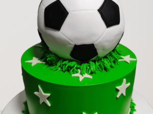 Custom football themed cake for kids, featuring a soccer ball design, goalposts, and green fondant field.