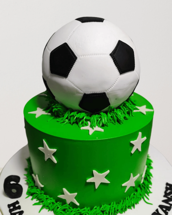 Custom football themed cake for kids, featuring a soccer ball design, goalposts, and green fondant field.