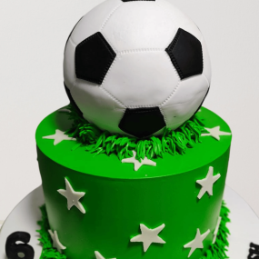 Custom football themed cake for kids, featuring a soccer ball design, goalposts, and green fondant field.